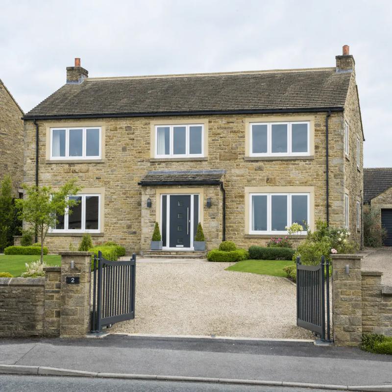 Detached Yorkshire stone house with new uPVC casement windows and anthracite grey composite front door