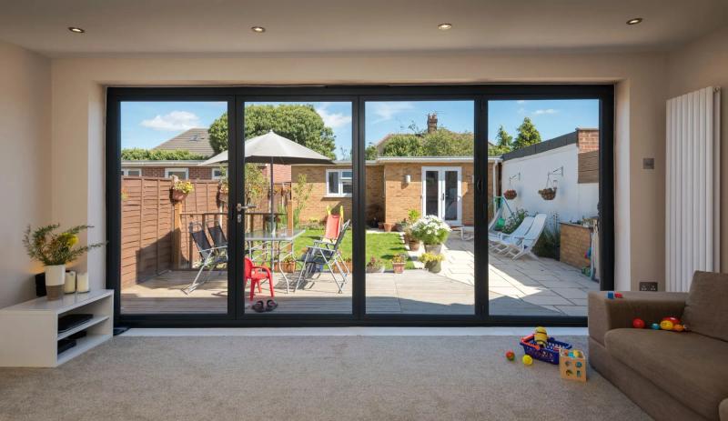 Wide aluminium bi-fold doors across a kitchen extension